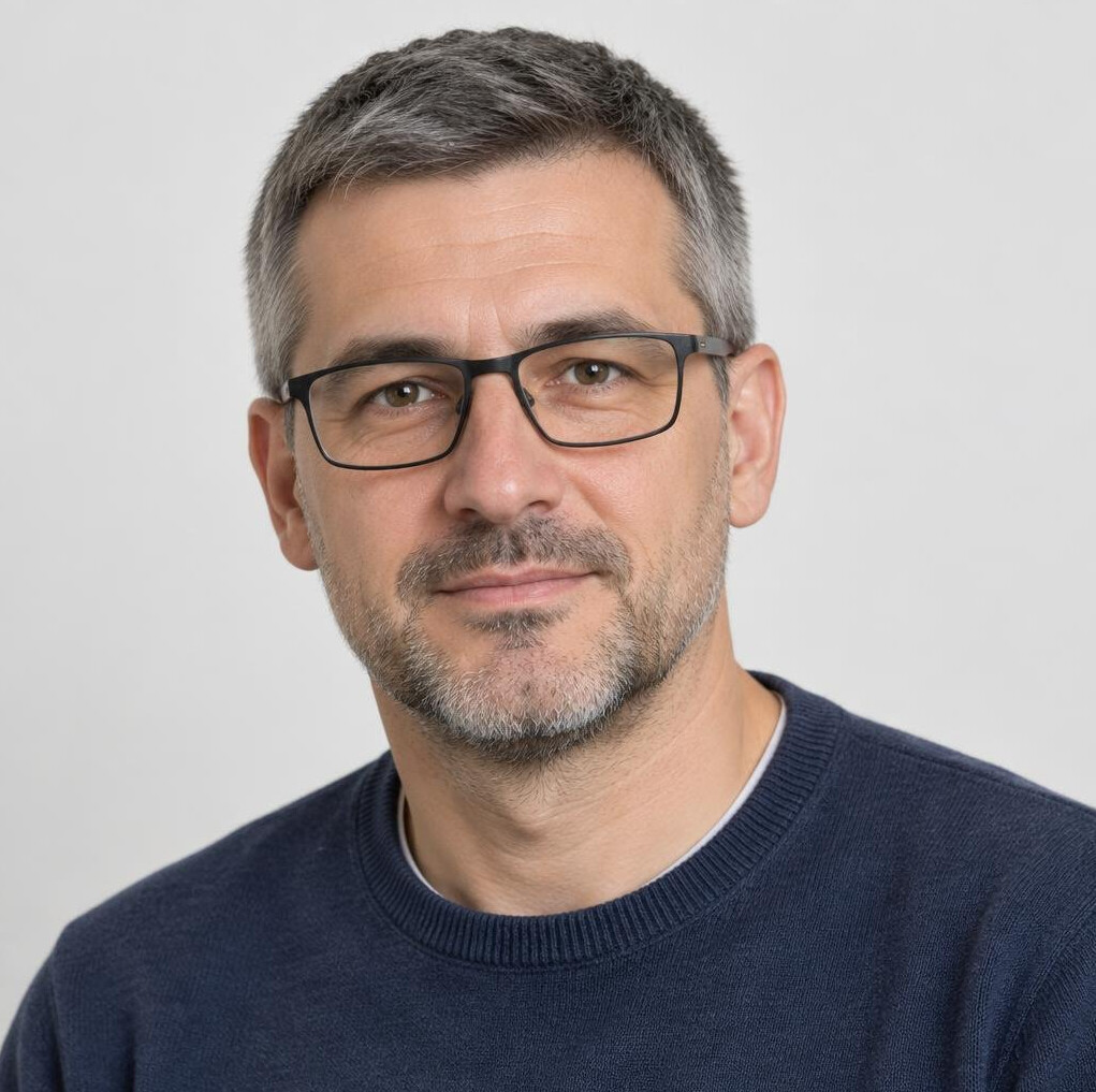 Studio portrait of a middle aged man with glasses